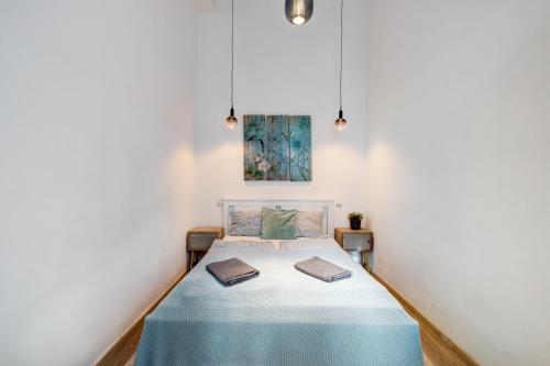 um quarto com uma cama numa parede branca em Elizabeth Garden Apartment em Budapeste