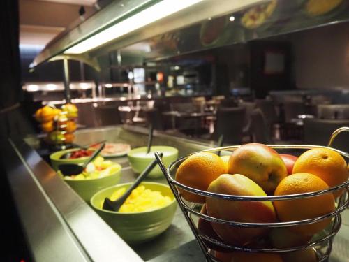a bowl of fruit on a counter in a restaurant at Holiday Inn Telford Ironbridge by IHG in Telford
