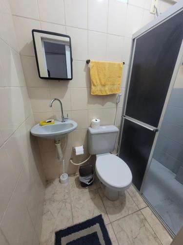 a bathroom with a toilet and a sink and a shower at Espaçosa kitnet em itapua 10 min da praia. in Vila Velha