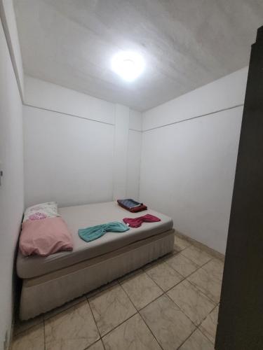 a small room with a bed with a light on it at Espaçosa kitnet em itapua 10 min da praia. in Vila Velha