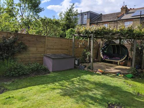 a backyard with a gazebo and a fence at Comfortable stylish room in Hanwell in Greenford