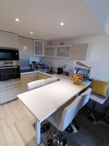 - une cuisine avec une table blanche et des chaises dans l'établissement Magnifique Duplex face à la Mer, à Saint-Cyr-sur-Mer