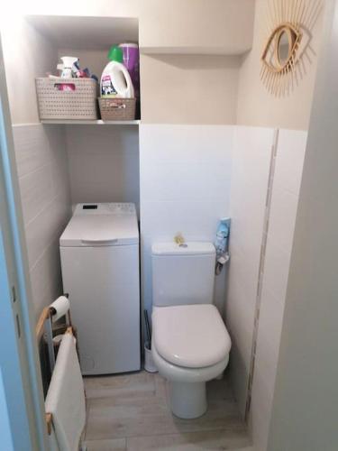 - une petite salle de bains blanche avec toilettes et étagères dans l'établissement Magnifique Duplex face à la Mer, à Saint-Cyr-sur-Mer