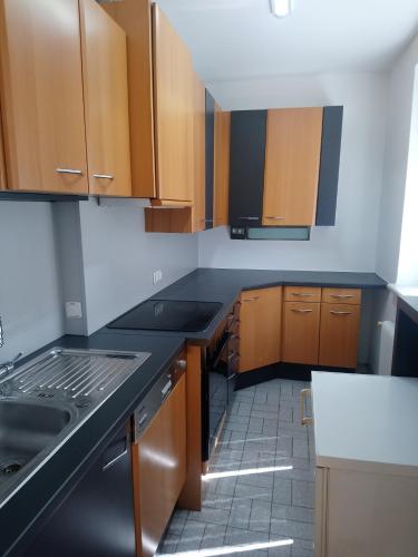 a kitchen with wooden cabinets and a black counter top at Melker Apartment in Melk
