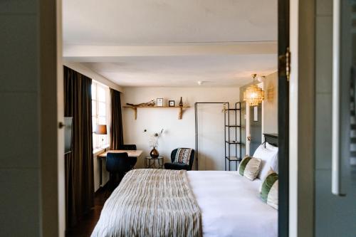 a hotel room with a bed and a desk at Boutique Hotel Hoog Soeren in Hoog-Soeren