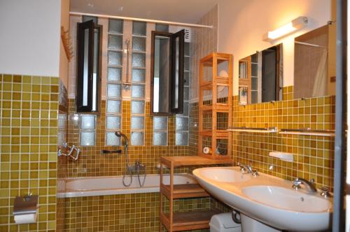 - une salle de bains carrelée de vert avec deux lavabos et une baignoire dans l'établissement Plein Ciel, à Bormes-les-Mimosas