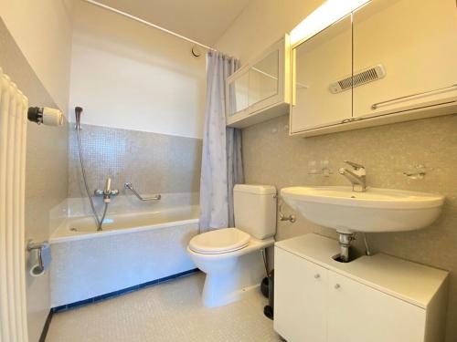 a bathroom with a sink and a toilet and a bath tub at Appartamento VistAcqua in Lugano