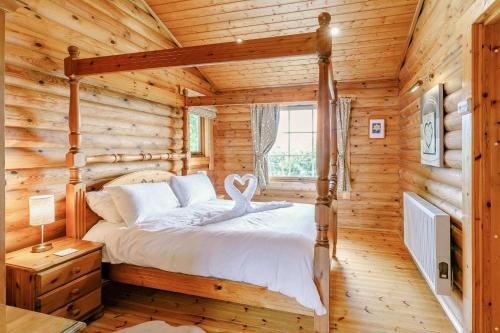 a bedroom with a bed in a log cabin at Faweather Grange in Bingley