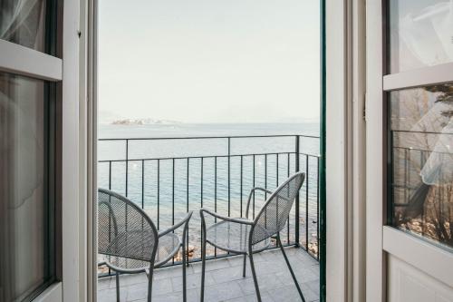 a balcony with two chairs and a view of the ocean at La casa sull'Isola Pescatori in Stresa