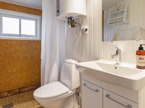 ein Bad mit einem WC, einem Waschbecken und einem Fenster in der Unterkunft Holiday home Væggerløse CCXIV in Bøtø By