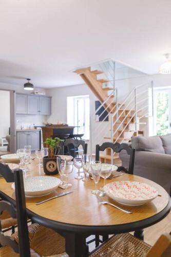 - une table à manger avec des verres et des assiettes dans l'établissement La Maison d’Élise - au cœur du village, à Pont-de-Vaux