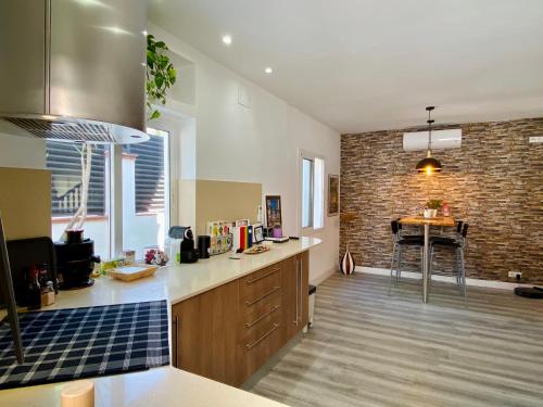 a kitchen with a counter and a brick wall at Villa Paradise, urban oasis by -Toprentalsbarcelona- in Esplugues de Llobregat