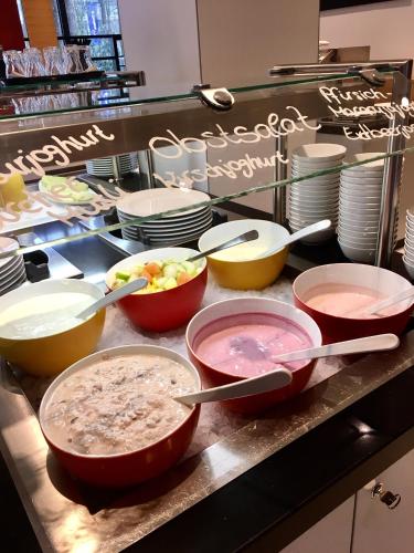 a counter with many bowls and plates and utensils at Lindner Hotel Frankfurt Sportpark, part of JdV by Hyatt in Frankfurt/Main