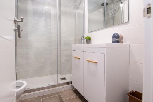 uma casa de banho branca com um chuveiro e um lavatório. em Rentalmar California em Salou