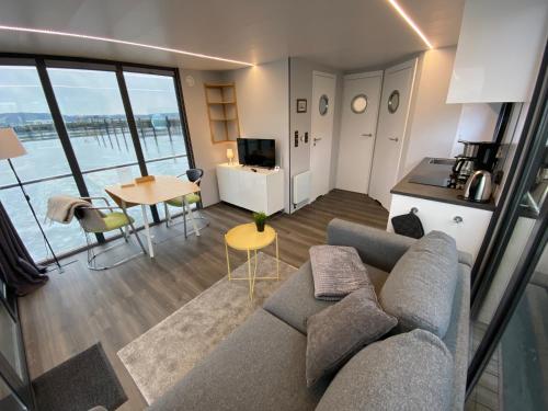 sala de estar con sofá y mesa en Hausboot Fjord Serina mit Biosauna in Schleswig, en Schleswig