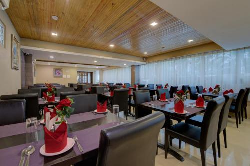 a conference room with tables and chairs with red flowers on them at Central Courtyard Boutique Hotel in Siliguri