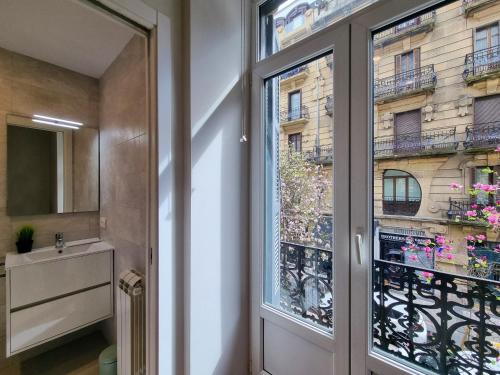 een badkamer met een raam met uitzicht op een gebouw bij Chillida Larramendi - Iberorent Apartments in San Sebastian