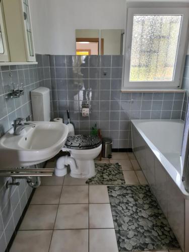 ein Badezimmer mit einem WC, einem Waschbecken und einer Badewanne in der Unterkunft Ferienwohnung Eva in Grebenhain