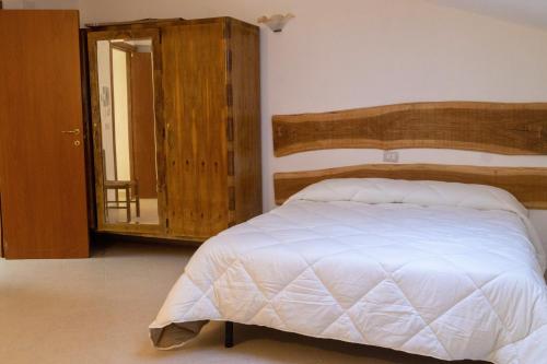 a bedroom with a bed with a wooden headboard and a mirror at Laetitia Guesthouse in Sepino