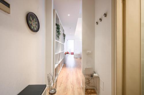 a hallway with white walls and a clock on a wall at tHE Lantern Flat in Milan