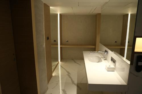 a bathroom with a white counter and a sink at Clarks Inn Suites Kangra in Kangra