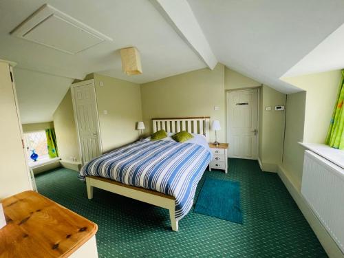 a bedroom with a bed with a blue carpet at Pentre Cerrig Country House in Llanferres