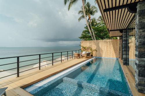 a swimming pool with a view of the ocean at Sea&Sky Beach Resort Beachfront Bungalows & Pool Villas in Mae Nam