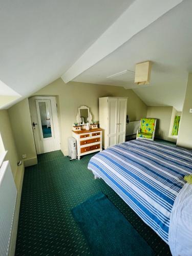 a bedroom with a large bed and green carpet at Pentre Cerrig Country House in Llanferres