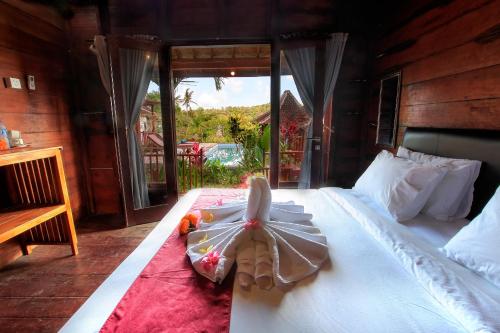 a bedroom with a bed with a toy on it at THE DARA HILL in Nusa Penida