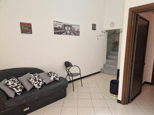 - un salon avec un canapé noir et un escalier dans l'établissement La Gardenia, à Licodia Eubea