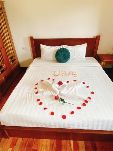 a bed with a heart made out of red roses at Opera Premier Hotel in Luang Prabang