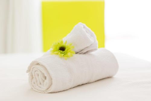 a white towel with a flower on top of it at Garau Petit Hotel in El Arenal