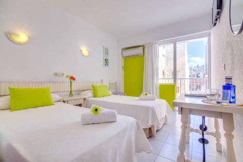 una camera d'albergo con due letti e una finestra di Garau Petit Hotel a El Arenal