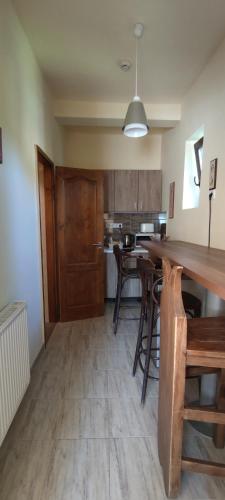 a kitchen with wooden floors and a table and chairs at Natura Panzió Szilvásvárad in Szilvásvárad
