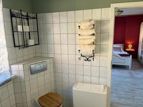 a bathroom with a toilet and towels on the wall at cafesahne u Pension in Dranske