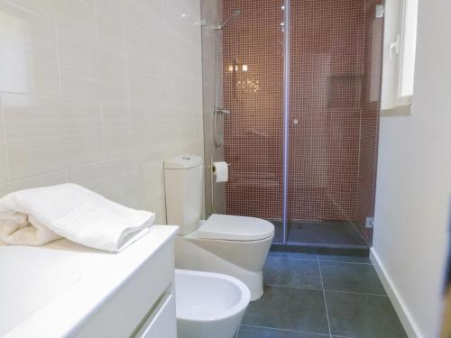 a white bathroom with a toilet and a shower at Watching Lisbon Apartments in Lisbon