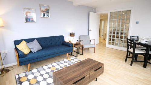 a living room with a blue couch and a table at Spacious apartment City Centre 5 guests long stay in Manchester