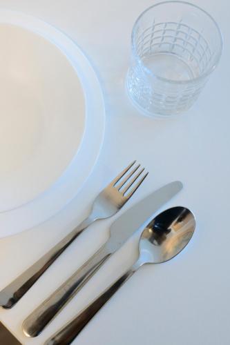 a fork and spoon next to a plate and a bowl at Smart & Stay Aparthotel Saarbrücken Süd - Self-Check-In - Free Parking in Saarbrücken