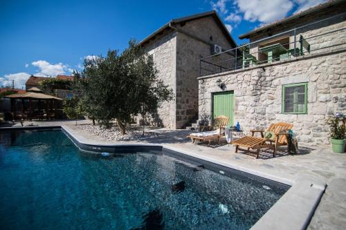 a house with a swimming pool next to a building at Villa Ana in Ivanica