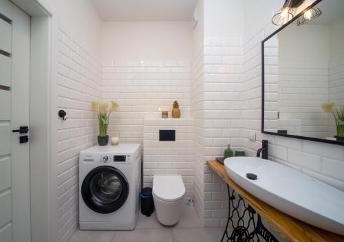 La salle de bains blanche est pourvue d'un lave-linge et d'un lavabo. dans l'établissement Maya's Flats & Resorts 62 - 3 rooms flat in Walowa Gdańsk, à Gdańsk