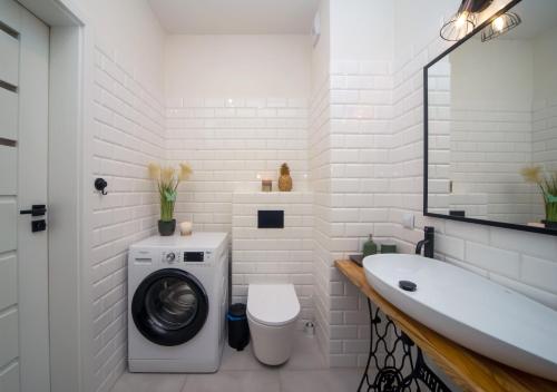 a white bathroom with a washing machine and a sink at Maya's Flats & Resorts 62 - 3 rooms apartment BASTION WALOWA Gdańsk in Gdańsk