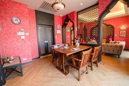 a dining room with red walls and a table and chairs at Amman Unique Hotel in Udon Thani