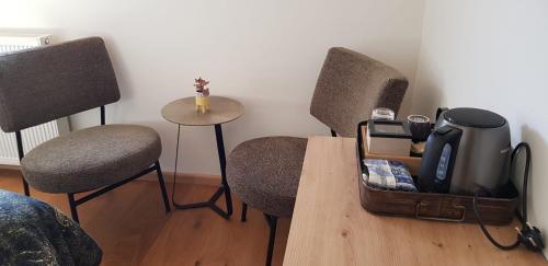 a room with two chairs and a table with a suitcase at Hoeve Ruimzicht Renesse in Renesse