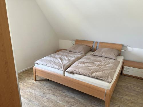 um quarto com uma cama e uma cabeceira em madeira em Ferienwohnung Niederbarge em Barge