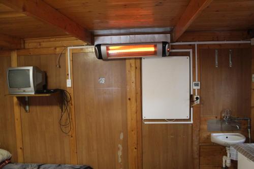 a room with a tv and a whiteboard on the wall at Camping domki letniskowe in Warsaw