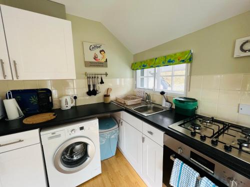 a kitchen with a washing machine and a sink at Pentre Cerrig Country House in Llanferres