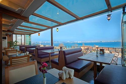 a restaurant with tables and chairs and a view of the ocean at Azade Suites in Istanbul