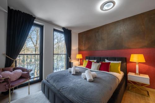 Rezydencja Strążyska في زاكوباني: غرفة نوم مع سرير كبير مع وسائد ملونة