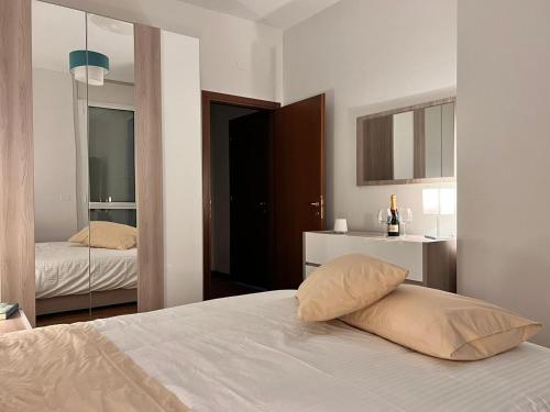 Habitación blanca con cama y espejo en APPARTAMENTO DE LUXE GIADA, en Bolonia