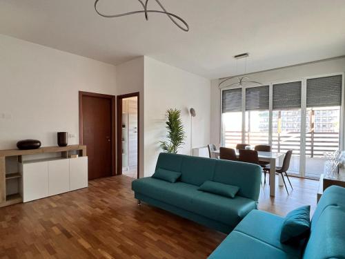 APPARTAMENTO DE LUXE GIADA في بولونيا: غرفة معيشة مع أريكة زرقاء وغرفة طعام